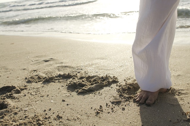 Person in white pants standing on a beach